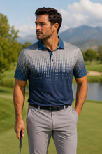 Load image into Gallery viewer, A man wearing a short-sleeve polo shirt with a gray-to-blue gradient dot pattern, standing on a golf course with mountains and trees in the background.