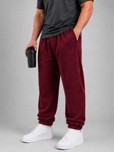 Load image into Gallery viewer, A man wearing heathered burgundy jogger sweatpants, a dark gray t-shirt, and white sneakers, holding a black shaker bottle against a solid gray studio background.