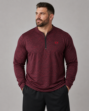 Load image into Gallery viewer, A man wearing a heathered burgundy long-sleeve quarter-zip pullover with a small red chest logo, paired with black pants, photographed against a solid gray studio background.