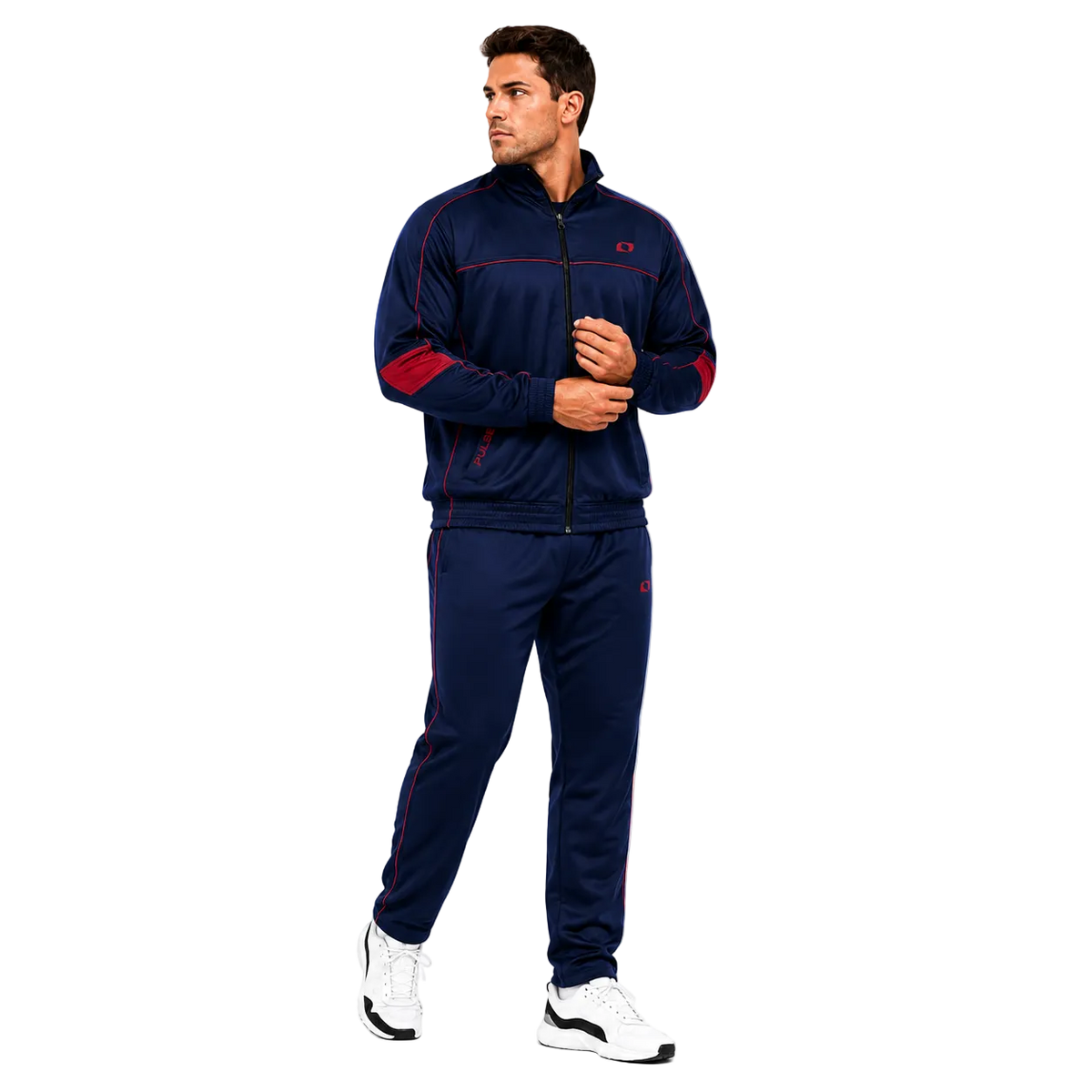 A man modeling a navy blue tracksuit with red accents, featuring a zip-up jacket and matching pants, paired with white sneakers, against a solid white background.
