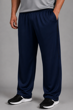 Load image into Gallery viewer, A person wearing navy blue athletic pants with side pockets, paired with a gray top and black sneakers, shown from the waist down against a plain gray studio background.
