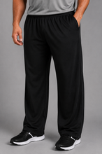 Load image into Gallery viewer, A man wearing black athletic pants with side pockets, paired with a gray t-shirt and black sneakers, shown from the waist down against a solid gray studio background.
