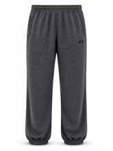 Load image into Gallery viewer, Dark gray heather sweatpants with an elastic waistband and cuffs, featuring a small black circular logo on the upper right hip, shown against a plain white background.
