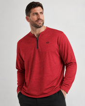 Load image into Gallery viewer, A man wearing a heather red long-sleeve quarter-zip pullover with a small black embroidered logo on the left chest, paired with black pants, against a light gray studio background.
