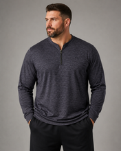 Load image into Gallery viewer, A man wearing a dark heather gray long-sleeve quarter-zip pullover and black pants, standing against a solid gray studio background.
