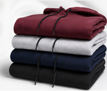 Load image into Gallery viewer, Four folded hooded sweatshirts stacked vertically on a white background, shown in maroon, light gray, navy blue, and black. Each hoodie has black drawstrings.
