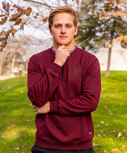 Load image into Gallery viewer, Person wearing a maroon sweater standing outdoors with trees and grass in the background
